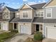 Street view of townhomes with single car garages and green lawns at 10133 Bessborough Dr, Raleigh, NC 27617