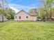 Back of house showing chain link fence surrounding a spacious lawn with mature trees at 104 Black Cloud Dr, Louisburg, NC 27549