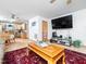 Cozy living room featuring a large flat-screen TV, light-colored wood floors, and a decorative area rug at 104 Black Cloud Dr, Louisburg, NC 27549