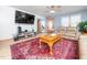 Stylish living room with a large TV, hardwood floors, comfortable seating, and access to other rooms at 104 Black Cloud Dr, Louisburg, NC 27549