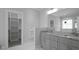Bright bathroom with double vanity, granite countertop, framed mirror, and closet access at 106 S Harper Faith Way, Benson, NC 27504