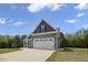 Lovely home featuring a two-car garage, stone details, gray siding, and a neatly maintained lawn at 106 S Harper Faith Way, Benson, NC 27504