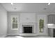 A beautiful fireplace with stone surround, white mantle, and a bright window nearby at 106 S Harper Faith Way, Benson, NC 27504