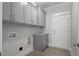 Functional laundry room with gray cabinets, granite countertop and convenient utility connections at 106 S Harper Faith Way, Benson, NC 27504
