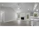 Open-concept living room with fireplace, door to deck, and gray kitchen with granite countertops at 106 S Harper Faith Way, Benson, NC 27504