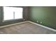 Bedroom featuring neutral carpet, a large window, and dark-green walls at 109 Bright Shade Ct, Holly Springs, NC 27540