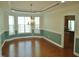 Dining room featuring hardwood floors, large bay window, elegant chandelier, crown molding, and wainscotting at 109 Bright Shade Ct, Holly Springs, NC 27540