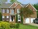 Charming two-story brick home with black shutters, mature landscaping, and a two-car garage at 109 Bright Shade Ct, Holly Springs, NC 27540
