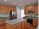 Spacious kitchen with an island, stainless steel fridge, and ample counter space, ideal for Gathering cooking at 109 Bright Shade Ct, Holly Springs, NC 27540