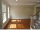 Spacious living room with hardwood floors, natural light from the windows, and staircase at 109 Bright Shade Ct, Holly Springs, NC 27540