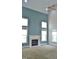 Cozy living room with a fireplace, large windows, and a vaulted ceiling at 109 Bright Shade Ct, Holly Springs, NC 27540