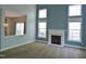 Bright living room featuring a fireplace, large windows, and open floor plan at 109 Bright Shade Ct, Holly Springs, NC 27540