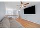 Upstairs bonus room featuring hardwood floors, ceiling fan, and a large TV, perfect for entertainment at 11011 Southwalk Ln, Raleigh, NC 27614
