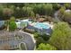 Aerial view showcasing the community pool, waterslide, tennis courts, and parking area at 11011 Southwalk Ln, Raleigh, NC 27614
