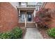 Inviting front porch with brick accents, a blue front door, and manicured landscaping at 11011 Southwalk Ln, Raleigh, NC 27614