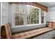 Close-up of window seat with plaid fabric, natural light, and built-in cabinets at 11011 Southwalk Ln, Raleigh, NC 27614
