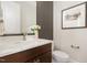 Stylish powder room with wood vanity, modern fixtures, and decorative wall art at 1221 Azalea Garden Cir, Raleigh, NC 27603