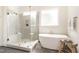 Bright bathroom featuring a free-standing tub and glass enclosed shower at 1221 Azalea Garden Cir, Raleigh, NC 27603
