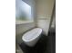Bathroom with freestanding tub, matte black tile flooring, and window with frosted glass at 1221 Azalea Garden Cir, Raleigh, NC 27603