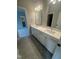 Bright bathroom featuring a double vanity with quartz countertops, modern fixtures, and a view of the walk in closet at 1221 Azalea Garden Cir, Raleigh, NC 27603