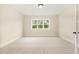 A neutral-toned empty room with a large window offering natural light at 1221 Azalea Garden Cir, Raleigh, NC 27603