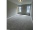 Spacious bedroom with plush carpeting, two windows providing natural light, and neutral walls at 1221 Azalea Garden Cir, Raleigh, NC 27603