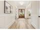 Elegant entryway with hardwood floors, white wainscoting, and a view of the front doors at 1221 Azalea Garden Cir, Raleigh, NC 27603