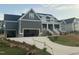 Beautiful new home features a spacious driveway leading to a three-car garage, complemented by landscaped front yard at 1221 Azalea Garden Cir, Raleigh, NC 27603