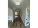 Inviting hallway with wood floors leads to a spacious room filled with natural light, perfect for entertaining at 1221 Azalea Garden Cir, Raleigh, NC 27603