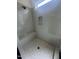 The tiled shower features a convenient built-in bench, stylish hexagonal tile, and bright natural light at 1221 Azalea Garden Cir, Raleigh, NC 27603