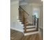 Modern staircase with wooden treads, black metal railings, and white risers at 1221 Azalea Garden Cir, Raleigh, NC 27603