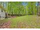 A home's backyard that features a lush, green, wooded area with a covered patio at 1332 Stallings Rd, Chapel Hill, NC 27516
