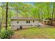 Home's backyard features a wooded area and a covered outdoor area with stone at 1332 Stallings Rd, Chapel Hill, NC 27516