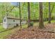 Backyard view with a wood-covered patio attached to a house surrounded by lush trees at 1332 Stallings Rd, Chapel Hill, NC 27516