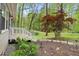 Landscaped front yard featuring a white porch and steps, garden, and a decorative tree at 1332 Stallings Rd, Chapel Hill, NC 27516