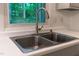 Stainless steel double-bowl sink with a modern faucet set against a bright window with view of outdoor greenery at 1332 Stallings Rd, Chapel Hill, NC 27516