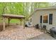 Exterior of home featuring a covered patio area with brick pavers, an outdoor seating arrangement, and privacy at 1332 Stallings Rd, Chapel Hill, NC 27516