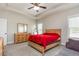 Spacious bedroom with a wood dresser, ceiling fan, and a comfortable bed with a red blanket at 158 Blande Dr, Kenly, NC 27542