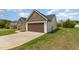 Two car garage attached to a single-story home with well manicured lawn at 158 Blande Dr, Kenly, NC 27542