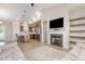 Open-concept living room featuring a fireplace, modern lighting, and flows into the kitchen with stainless appliances at 158 Blande Dr, Kenly, NC 27542