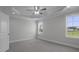 Sunlit bedroom with neutral walls, ceiling fan, recessed lights, and carpeted floor with scenic views at 163 S Harper Faith Way, Benson, NC 27504