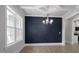 Dining room showcasing a dark blue accent wall, modern chandelier, and natural light at 163 S Harper Faith Way, Benson, NC 27504