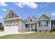 Attractive home exterior with blue siding, stone veneer, dormer windows and a two-car garage at 163 S Harper Faith Way, Benson, NC 27504