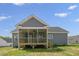 Exterior back view featuring a screened-in porch, gray siding, and a well-manicured lawn at 163 S Harper Faith Way, Benson, NC 27504