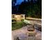Backyard with a fire pit area, patio, and landscaped garden with accent lighting at 1802 Greenbriar Rd, Henderson, NC 27536