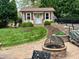 Charming backyard featuring a cozy shed, well-manicured lawn, and inviting stone fire pit area at 1802 Greenbriar Rd, Henderson, NC 27536