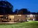 Backyard at dusk featuring a covered patio and manicured lawn at 1802 Greenbriar Rd, Henderson, NC 27536