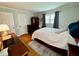 This bedroom boasts hardwood floors, fresh paint, a comfortable bed and great natural light from the window at 1802 Greenbriar Rd, Henderson, NC 27536