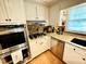 Well-lit kitchen featuring granite countertops, stainless steel appliances, and light wood floors at 1802 Greenbriar Rd, Henderson, NC 27536