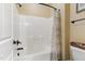 Bright bathroom featuring a white shower-tub combo with dark fixtures and patterned shower curtain at 181 Fawn Hill Ct, Garner, NC 27529
